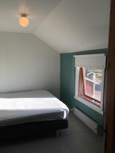 a bedroom with a bed and a window at Storjord Farmstay Ranchhouse in Kvaløya