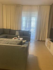 a living room with a blue couch and a tv at مارينا KAEC in King Abdullah Economic City