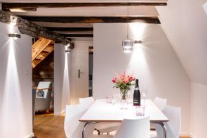 Michaelis Suite - Schrangen-Suites-1389 في لونبورغ: غرفة طعام مع طاولة بيضاء وكراسي بيضاء