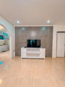 Isabela Province Staycation House في Cordon: غرفة معيشة مع تلفزيون بشاشة مسطحة على جدار