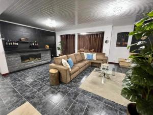 a living room with a couch and a fireplace at Hollywood villa in Campanário