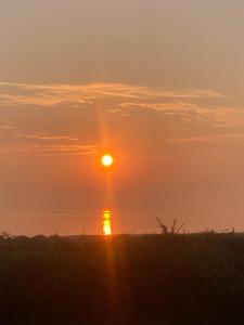 a sunset over the water with the sun in the sky at Oranuisce Thatch Cottage Ballyvaughan in Ballyvaughan