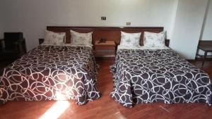 twee bedden naast elkaar in een slaapkamer bij HOTEL PARQUE VIA in Mexico-Stad