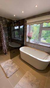 ein großes Bad mit einer Badewanne und einem Fenster in der Unterkunft Stunning double bedroom Greenwich London, in London