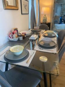 a glass table with bowls and plates on it at Oranuisce Thatch Cottage Ballyvaughan in Ballyvaughan