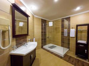 a bathroom with a sink and a shower and a toilet at Black Diamond Hotel in Lagos