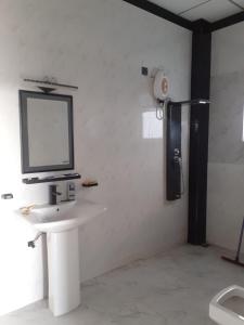 łazienka z umywalką i telewizorem na ścianie w obiekcie Rohan's Residence w mieście Kandana