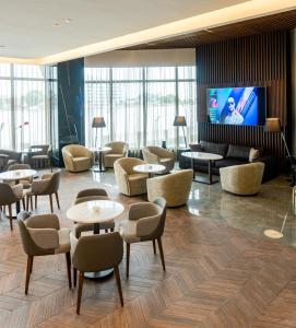 a lobby with tables and chairs and a flat screen tv at Black Diamond Hotel in Lagos