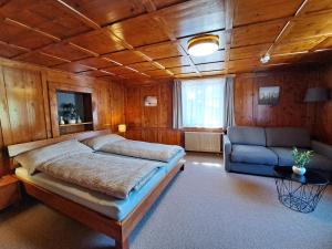 a bedroom with a large bed and a couch at Casa Crap in Trin