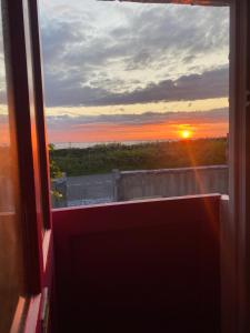 a view from a window of a sunset at Oranuisce Thatch Cottage Ballyvaughan in Ballyvaughan