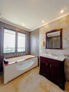 a bathroom with a tub and a sink and a mirror at Black Diamond Hotel in Lagos