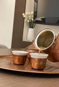 a tray with three cups and a pot on a table at TIM Apartment Sarajevo with private Parking in Sarajevo