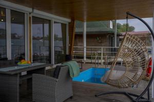 a patio with a chair and a table and a swing at Splav Nala in Belgrade