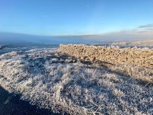 a stone wall sitting on top of a field at Oranuisce Thatch Cottage Ballyvaughan in Ballyvaughan