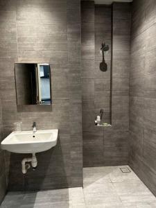 uma casa de banho com um lavatório e um espelho em A.R Homestay Riverine Condominium (Riverview)(A) em Kuching
