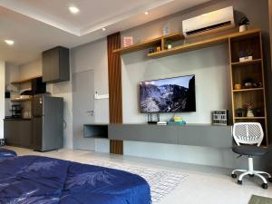um quarto com uma cama e uma televisão na parede em A.R Homestay Riverine Condominium (Riverview)(A) em Kuching