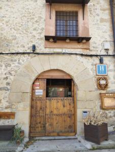 a stone building with a wooden door and a window at Hotel Rural Abuelo Rullo in Terriente