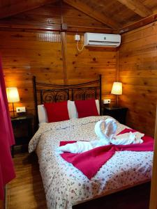 1 dormitorio con 1 cama con almohadas rojas en El Paraje del Chef, en Laroles