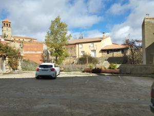 un coche blanco aparcado en un estacionamiento en Hotel Rural Abuelo Rullo, en Terriente