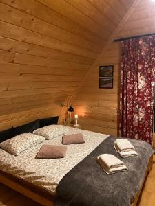 a bedroom with a bed in a log cabin at Domki Widokowe -Przystanek Salamandra in Kościelisko