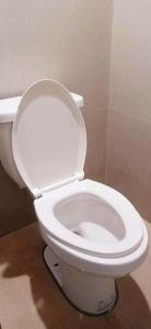 a white toilet with the lid up in a bathroom at Eastdee Homestay - Aircon Room 108 in Lidlidda