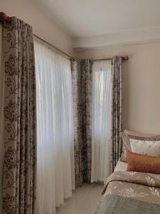 a bedroom with a bed and a window with curtains at Condo , WIFI up to 100mbps , Infinity Pool in Cebu City