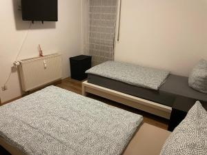 a room with two beds and a flat screen tv at Ferienwohnung mit 2 Zimmer, Küche, Bad, in Saarbrücken in Saarbrücken