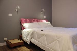 sypialnia z białym łóżkiem z czerwonym zagłówkiem w obiekcie La Casa dell'Uva, Marino w mieście Marino
