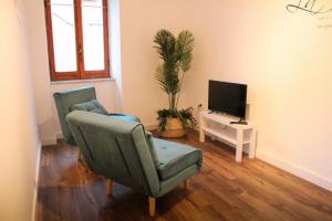 salon z 2 krzesłami i telewizorem w obiekcie La Casa dell'Uva, Marino w mieście Marino