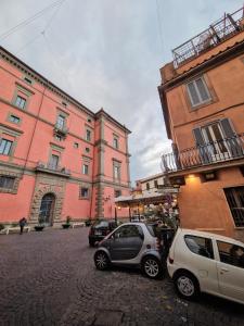 dwa samochody zaparkowane na ulicy przed budynkami w obiekcie La Casa dell'Uva, Marino w mieście Marino
