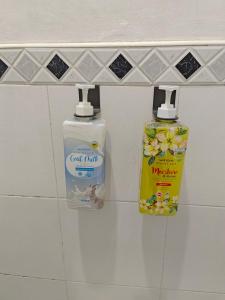 2 botellas de productos de limpieza en un estante del baño en Best Inn Lahug, en Cebú
