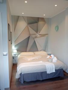 a bedroom with a large bed with a geometric wall at Casa Vacanze MURANUM - B&B in Morano Calabro