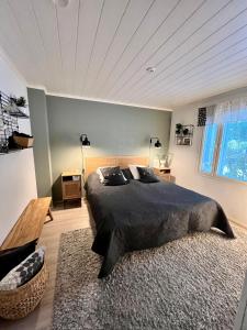 a bedroom with a large black bed and a rug at Villa Aurora View in Rovaniemi