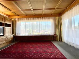 a room with a large window and a red rug at Haus St. Georg in Seefeld in Tirol