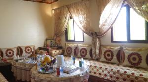salon z kanapą ze stołami i oknami w obiekcie Maison AFA w mieście Tafraout