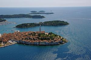 an island in the water with a lighthouse on it at Sunny Rock Volme Apartments in Banjole