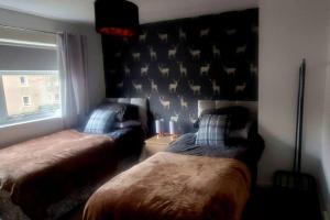 a bedroom with two beds and a window at Cosy 2 bedroom house on the edge of Balloch in Balloch