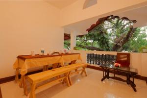 una sala da pranzo con tavolo, panca e finestra di Kochi Vibes Homestay a Cochin