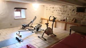 una stanza con due cyclette su un pavimento piastrellato di CHALEUREUX COTTAGE, PISCINE PATIO a Tayrac
