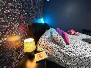 a bedroom with a bed with a lamp and a wall at Boutique Annexe Close To Central Norwich & Airport in Norwich