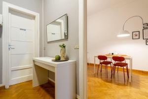 米兰CentralStation - Via Lazzaroni的白色的厨房配有桌子和2把红色椅子 更多89张照片