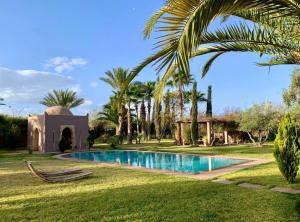 ein Resort mit einem Pool und Palmen in der Unterkunft Dar Zeitoun in Marrakesch