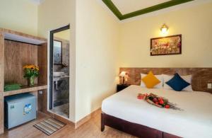 a bedroom with a bed with flowers on it at Green Bud hostel and homestay in Hoi An