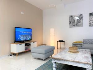uma sala de estar com uma televisão e uma cadeira azul em Stadtsuite mit Sauna in Wiener Neustadt 135 m2 em Wiener Neustadt
