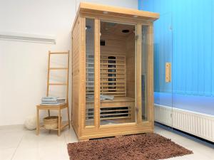 Stadtsuite mit Sauna in Wiener Neustadt 135 m2 في وينر نويشتاد: خزانة خشبية مع أبواب زجاجية في الغرفة