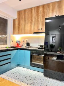 a kitchen with blue cabinets and black appliances at Corner Penthouse Apartment in the center of Skopje in Skopje