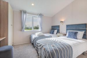 a bedroom with two beds and a window at Birch Timber Holiday Lodge in Bassenthwaite