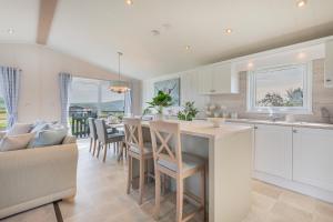 a kitchen and dining room with a table and chairs at Birch Timber Holiday Lodge in Bassenthwaite