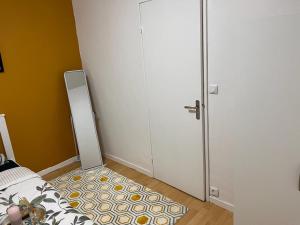 a bedroom with a bed and a door with a rug at 2 Superbes chambres d hôte dans un appartement avec magnifique vue sur Paris in Sucy-en-Brie