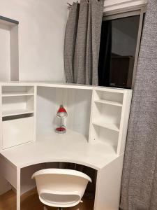 a white desk with a lamp in a room at 2 Superbes chambres d hôte dans un appartement avec magnifique vue sur Paris in Sucy-en-Brie